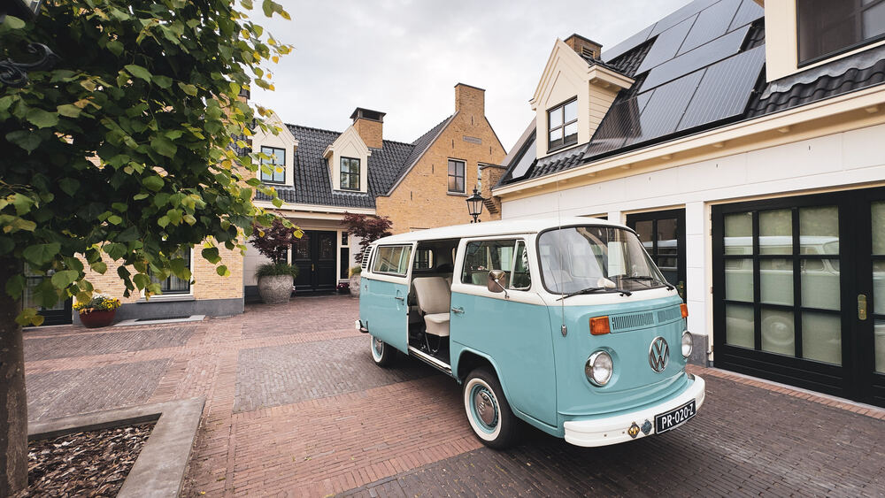 De bus geparkeerd voor de garage, schuin van voren.