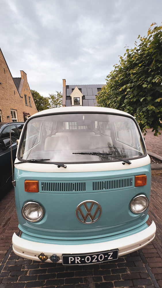De klassieke bus staand in beeld, schuin van voren met chroomwerk in de zon.