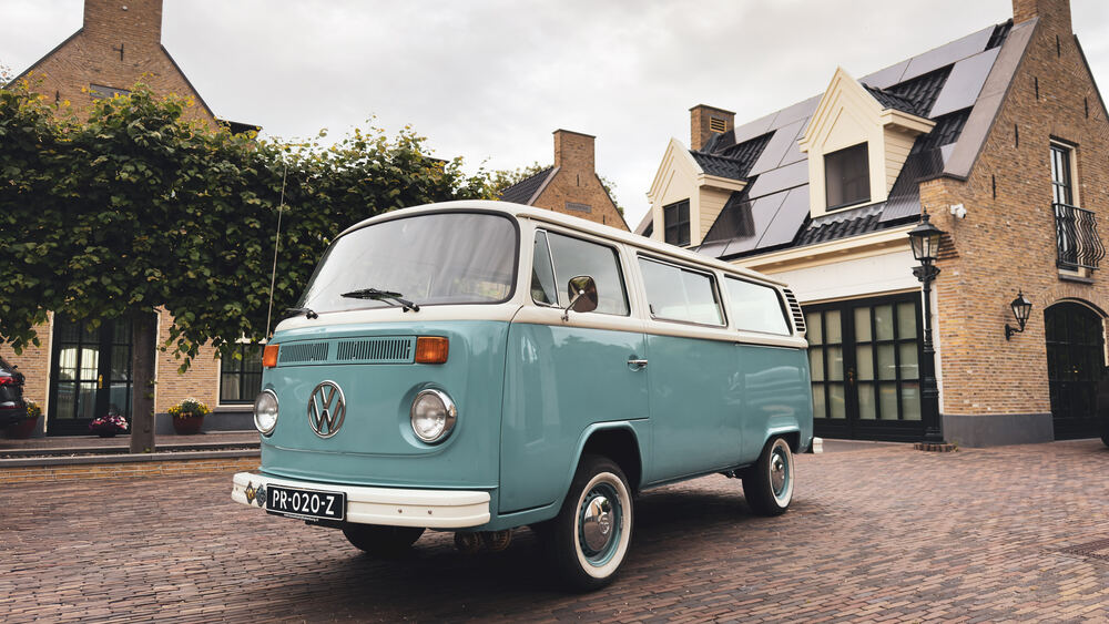 De VW T2 schuin van voren, met geel-zwart chroomwerk en Nederlands kenteken.