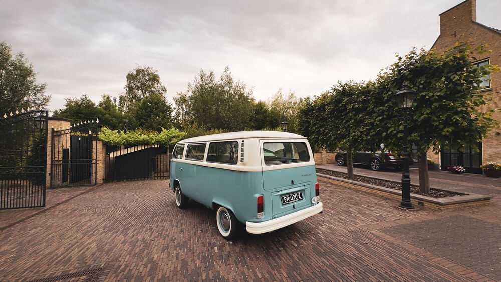 Het volledige zijaanzicht van de tweekleurige VW-bus, zeegroen onder crème.
