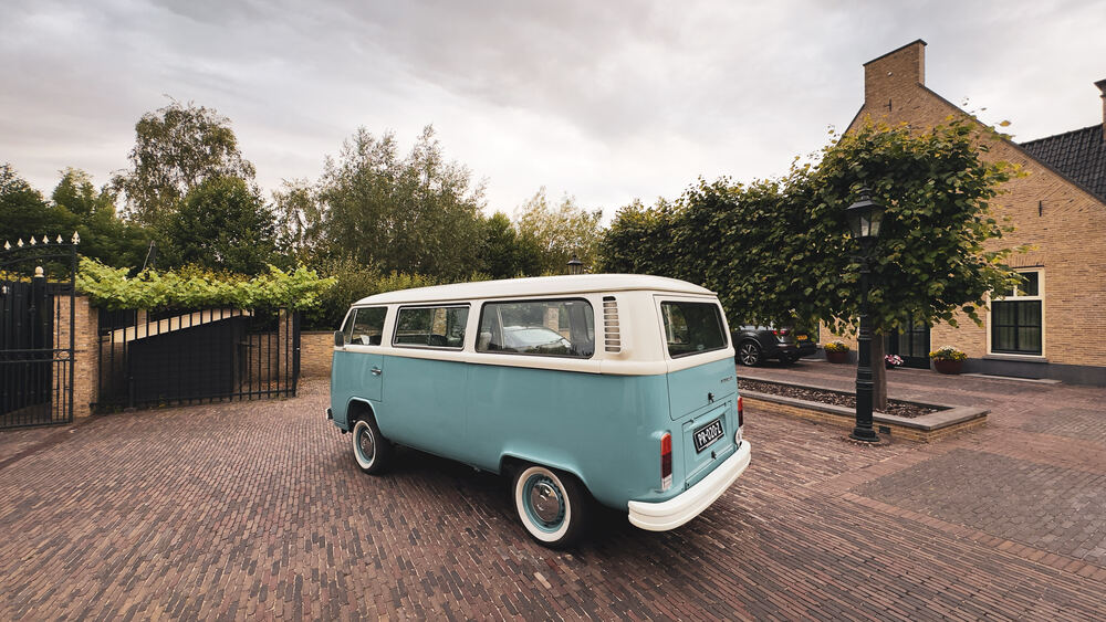 De VW-bus van achteren-opzij gezien, met de achterklep en zijraam.